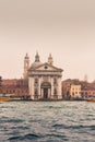 View of historical buildings surrounded by water in the morning mist in the city of Venice
