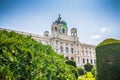 view of the Hofburg Palace from the side of the Burggarten park. landscape of the park with neatly trimmed bushes, green lawn and