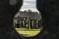 View through the hole in a wall on a graveyard Royalty Free Stock Photo