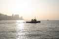 View of Hong Kong Victoria Harbor at sunset with boat sailing by Royalty Free Stock Photo