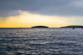 View of the horizon over the Adriatic Sea, with a boat sailing, during the sunset of a cloudy day while raining