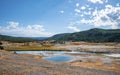 View of hot spring in Geyser Basin at Yellowstone park with sky in background