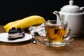 View of hot tea in transparent cup and slice of blueberry cheesecake in white ceramic dish