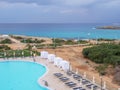 View from the hotel balcony over Nissi promenade between blue sea and empty swimming pool Royalty Free Stock Photo