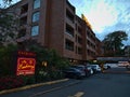 View of hotel Embassy Inn with brick facade in Victoria downtown with entrance sign and parking lot.