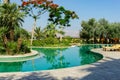 View of the hotel Kempinski Ishtar Dead Sea in Jordan. Emerald water surface of pools and palm trees. Concept of tourism,