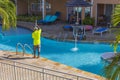 View of hotel\'s employee cleaning outdoor pool. Aruba.