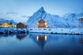 View on the house in the Sarkisoy village, Lofoten Islands, Norway. Landscape in winter time during blue hour. Mountains and water