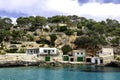 A view of houses with boat garages and azure sea water, Cala Llombards, Mallorca island