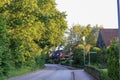 View of houses and empty road with lamp post in rural Germany with trees and bright sky background Royalty Free Stock Photo