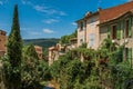 View of houses near creek and bluff with vegetation in Moustiers-Sainte-Marie. Royalty Free Stock Photo