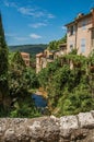 View of houses near creek and bluff with vegetation in Moustiers-Sainte-Marie. Royalty Free Stock Photo