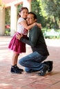 View of hug and kiss of Latino 8 year old father and girl in outdoor park