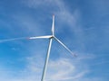 View on huge white wind generator on blue sky and white clouds background. Nature friendly wind energy technology. Windmill in Eur