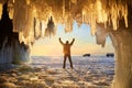 View from the ice cave with huge icicles on the frozen Lake Baikal at sunset. Royalty Free Stock Photo