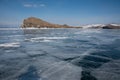 view of ice covered water surface of lake and rock formations on background, Russia,