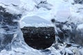 View of icebergs on the shore through a round transparent ice frame. Diamond Beach. Iceland.