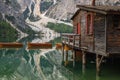 View of iconic boathouse and boats with mount Seekofel mirroring in Pragser Wildsee Lago di Braies Italy