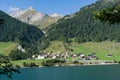 View of an idyllic and picturesque turquoise mountain lake surrounded by green forest and mountain peaks in the Swiss Alps