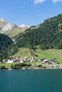 View of an idyllic and picturesque turquoise mountain lake surrounded by green forest and mountain peaks in the Swiss Alps