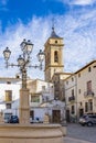 View of Iglesia del Salvador from behind the fountain with beautiful lantern on the Plaza de Albornoz Square in Requena, Spain