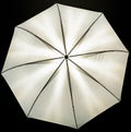 A view of the illuminated photo umbrella - a light softener - black background