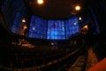 View of the indoor Kaiser Wilhelm Memorial Church in Berlin with warm light and the blue stainless glass