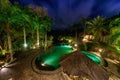 View of infinity swimming pool at luxurious jungle villa. Beautiful garden by night Royalty Free Stock Photo