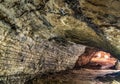 View inside the ancient cave with stone walls with additional lighting. Texture of a stone wall in a cave Royalty Free Stock Photo