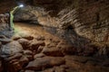 View inside the ancient cave with stone walls with additional lighting. Texture of a stone wall in a cave Royalty Free Stock Photo