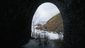 View from inside of arcuate tunnel on a frozen lake and the mountain. Clip. Aerial view of the icy water reservoir with Royalty Free Stock Photo