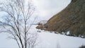 View from inside of arcuate tunnel on a frozen lake and the mountain. Clip. Aerial view of the icy water reservoir with Royalty Free Stock Photo