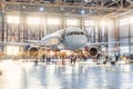 View inside the aviation hangar, the airplane mechanic working around the service Royalty Free Stock Photo