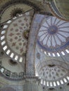 View from inside the beautiful domed roof of a mosque with beautiful decorations and blue tile design. Istanbul, Turkey