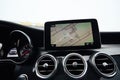 View from inside a car on a part of dashboard with a navigation unit and blurred street in front of a car Royalty Free Stock Photo