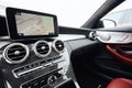 View from inside a car on a part of dashboard with a navigation unit and blurred street in front of a car Royalty Free Stock Photo