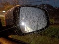 View from inside car through window to see wing mirror while of blur background at night time Royalty Free Stock Photo