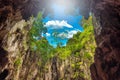 View from inside a cave looking out tree and blue sky Royalty Free Stock Photo