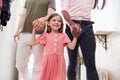 View Inside Hallway As Same Sex Male Couple With Daughter Open Front Door Of Home