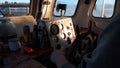 View inside of pilothouse with windows, compass, steering wheel, and dashboard. Clip. A man sailor leading its old and