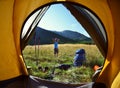 View from inside a tent on the girl and mountains