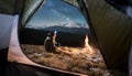 Male tourist have a rest in his camping in the mountains at night under beautiful night sky full of stars and milky way Royalty Free Stock Photo