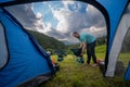 View from inside the tourist tent. Setting up a camp night. Man Installation of portable chairs and a table, dinner with a view on