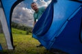 View from inside the tourist tent. Setting up a camp night. A man opens the entrance to a tent. Hiking and travel concept.