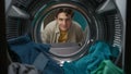 View from inside the washing machine, adult man looking at the camera and smiling Royalty Free Stock Photo