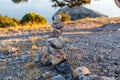 View on inuksuk pyramid of rocks in balance and bushes lit wit