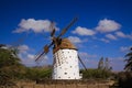 View on ancient white windmill with brown wings against blue sky with few scattered clouds - Fuerteventura, El Cotillo