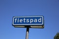 View on isolated dutch sign against blue sky with word fietspad english: cycling track