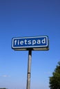 View on isolated dutch sign against blue sky with word fietspad english: cycling track