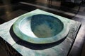 View on isolated green blue old medieval marble stone baptismal font illuminated by natural sunlight in catholic church - Brugge, Royalty Free Stock Photo